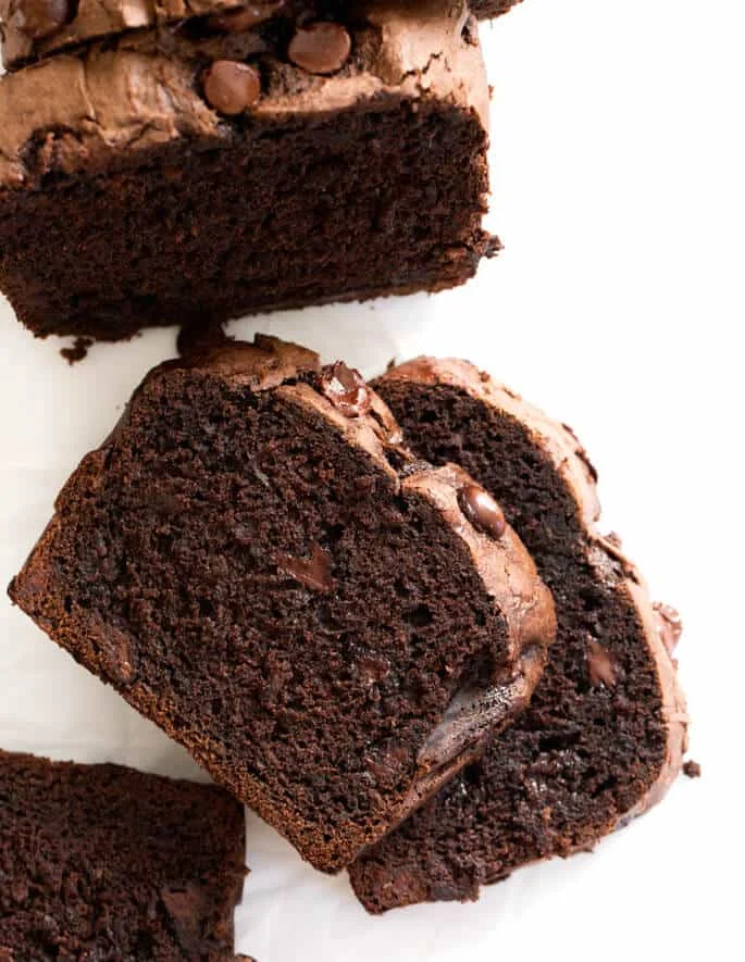 Overhead image of sliced double chocolate zucchini bread on white paper