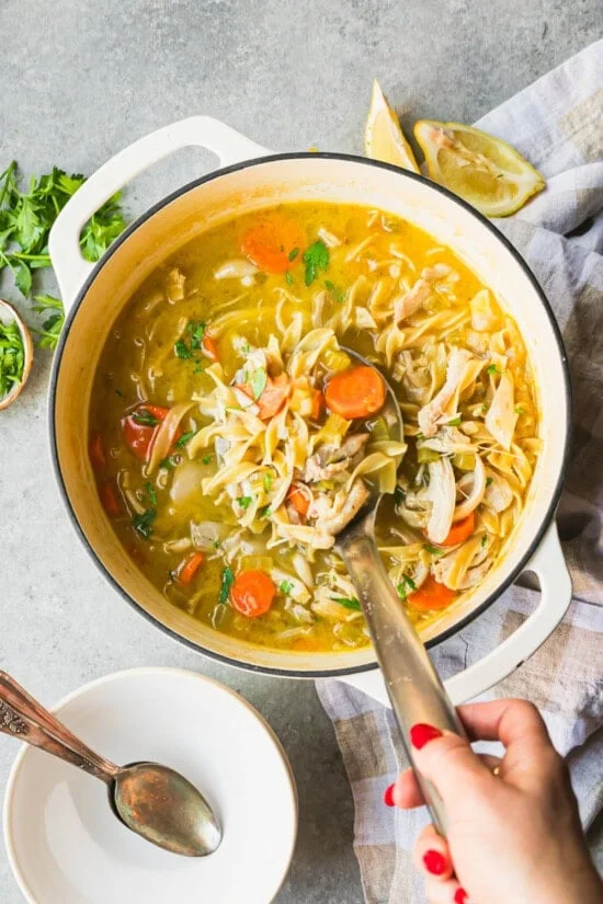 Overhead view of a pot of chicken noodle soup.