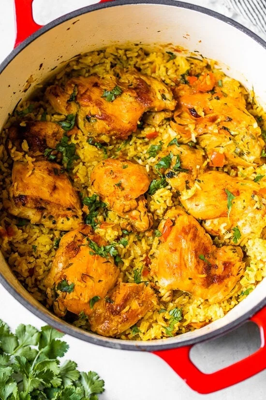 Overhead view of Arroz Con Pollo in a red Dutch oven.