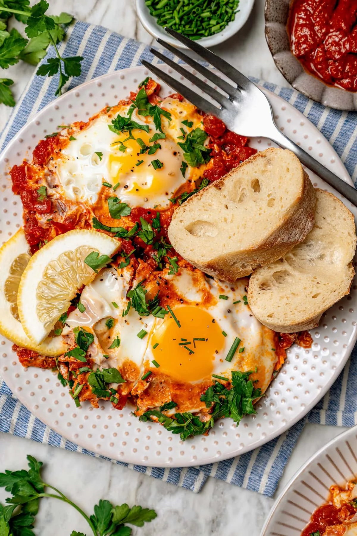 Overhead view of eggs in purgatory on plate with slices of bread