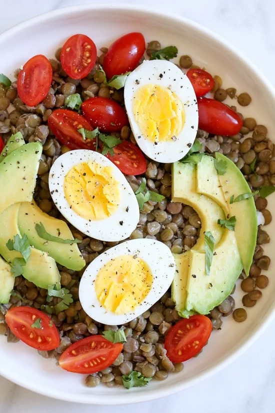 Overhead view of lentil salad with avocado and hard boiled eggs