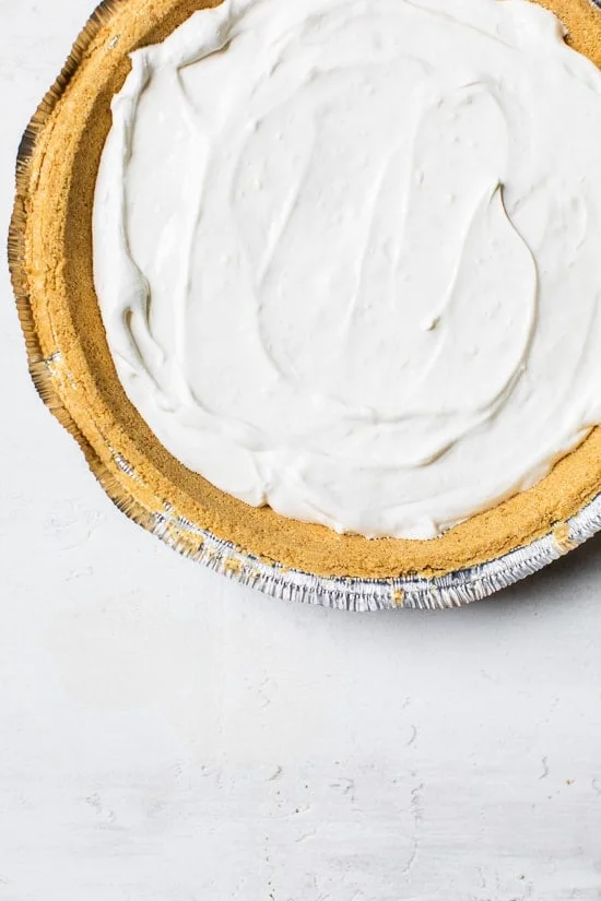 Overhead view of no-bake cheesecake filling added to crust