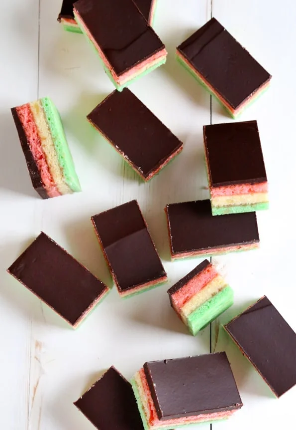 Overhead view of rainbow cookies on white surface.