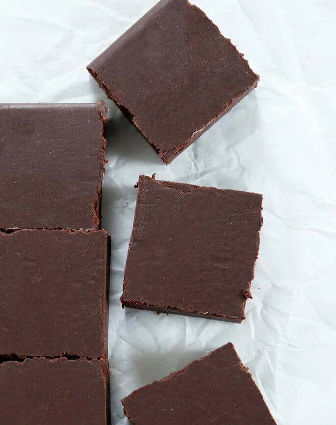 Overhead view of slices of vegan fudge on white paper 