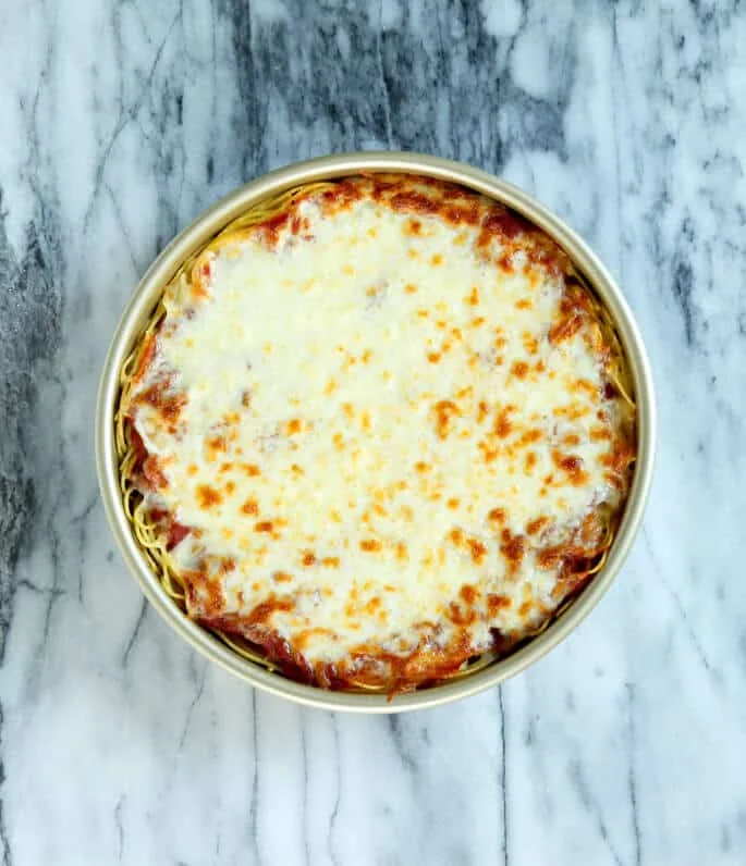 Overhead view of spaghetti pie in metal dish.