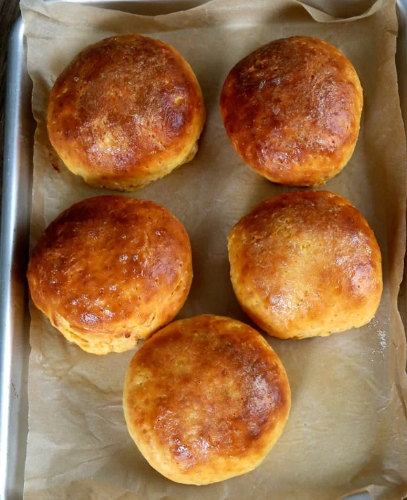 Overhead view of Sweet Potato Browned Butter Rolls on beige surface 