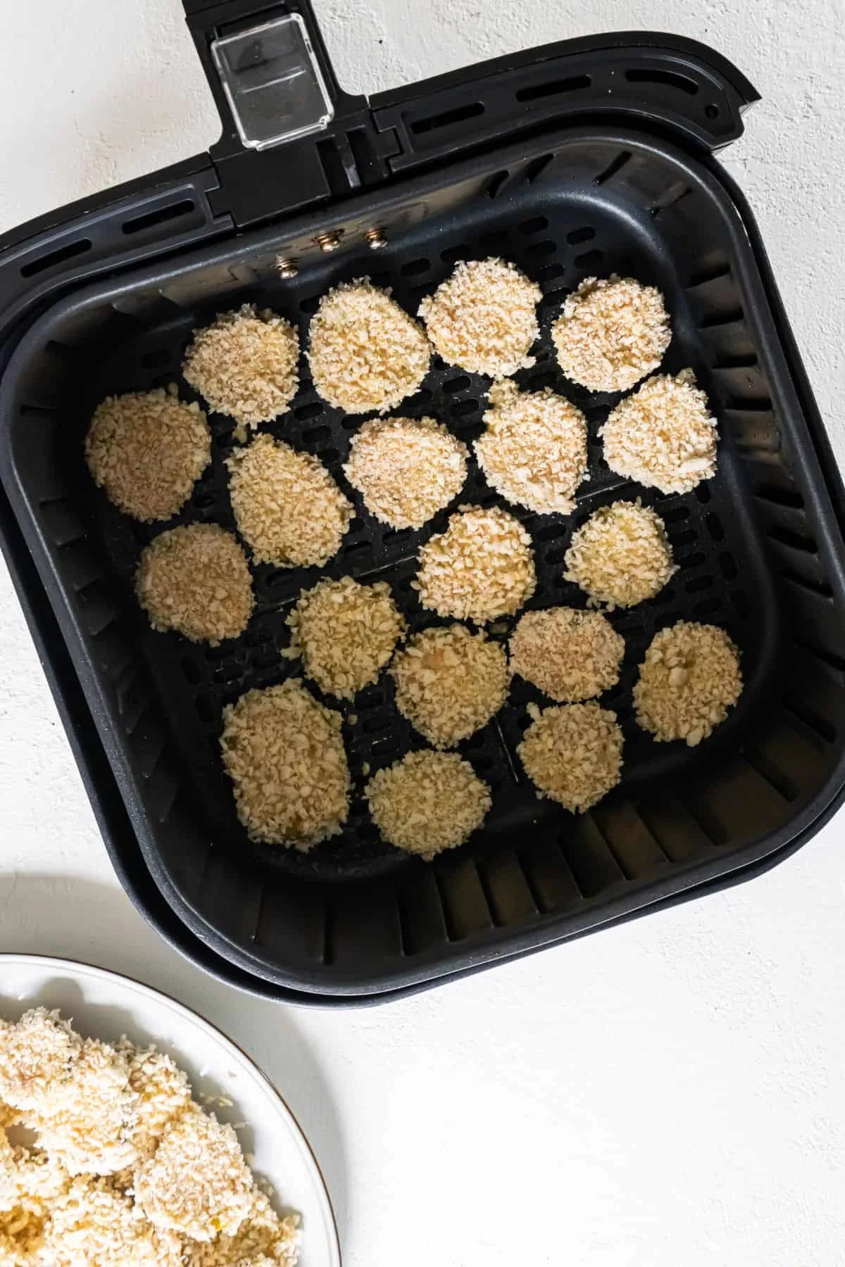 Pickles in an air fryer about to be air fried.