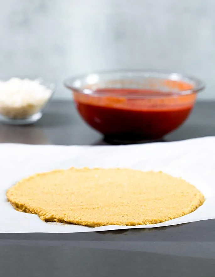Pizza crust being prepared on the counter top. 