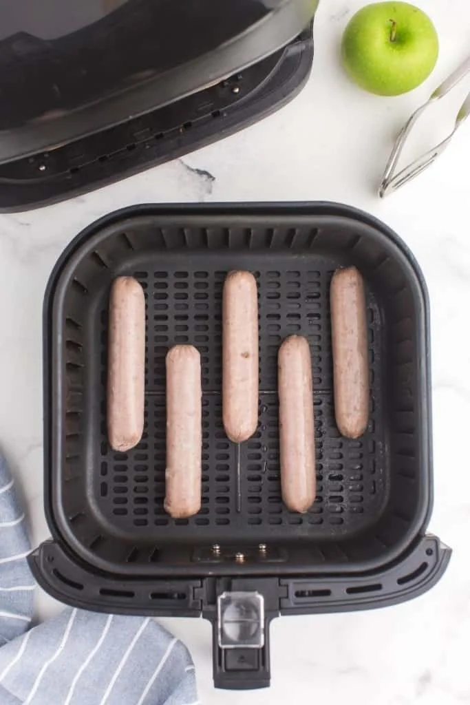 place chicken sausages in air fryer with space between each one
