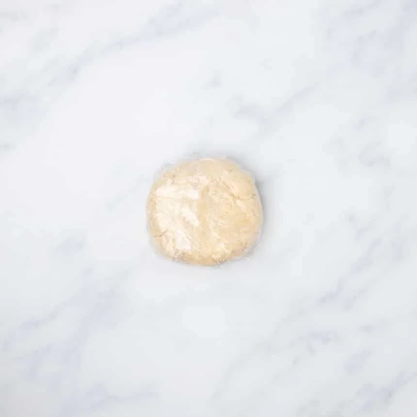 plastic wrapped tightly around cracker dough disk