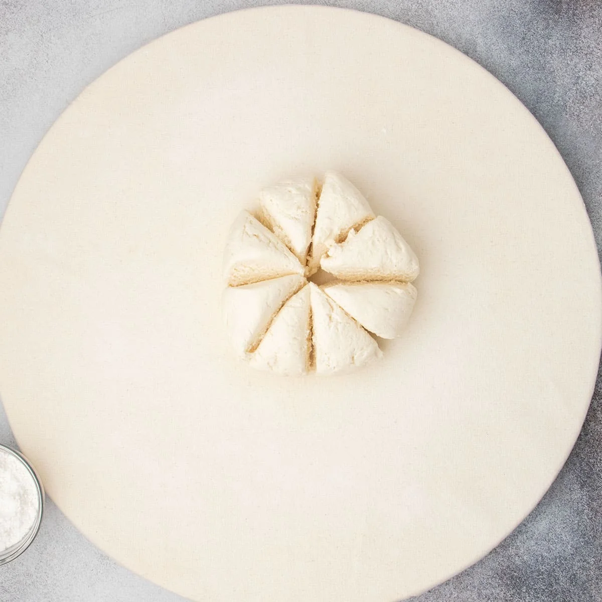 Proofed raw dough cut into 8 even wedges, ready to be shaped.