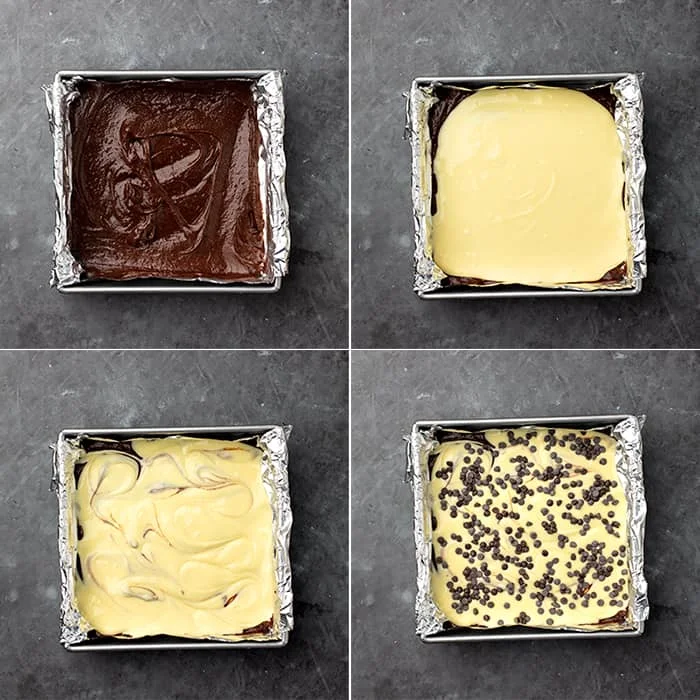Raw brownie layer in pan topped with cheesecake, swirled, then topped with chips
