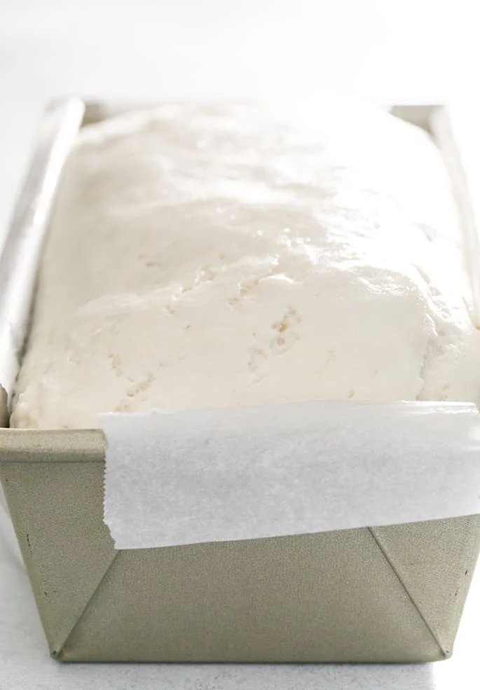 Raw English muffin bread dough in pan that rose.