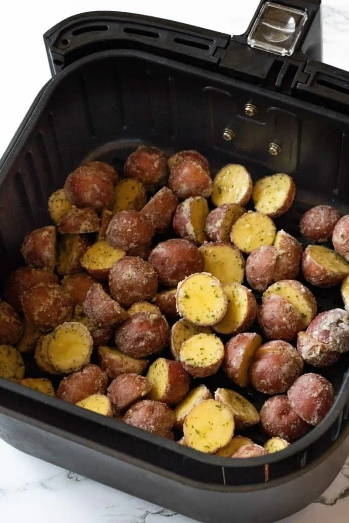 Raw ranch potatoes inside air fryer basket