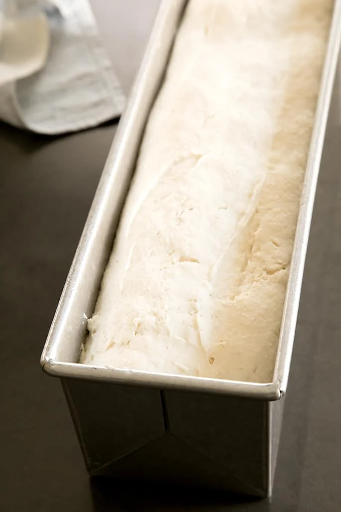 Raw soft bread dough in a 2 pound metal pullman pan.