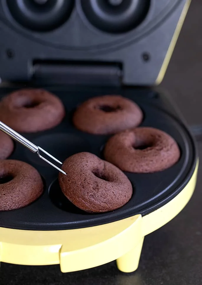 removing gluten free chocolate cake donuts from a donut maker