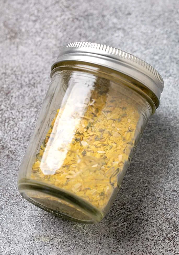 Rice a roni seasonings in small mason jar with lid on its side on gray surface