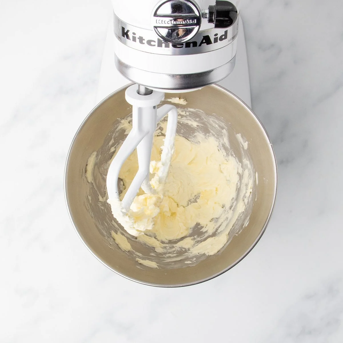 Room temperature butter partially creamed in the bowl of a stand mixer fitted with a paddle attachment.
