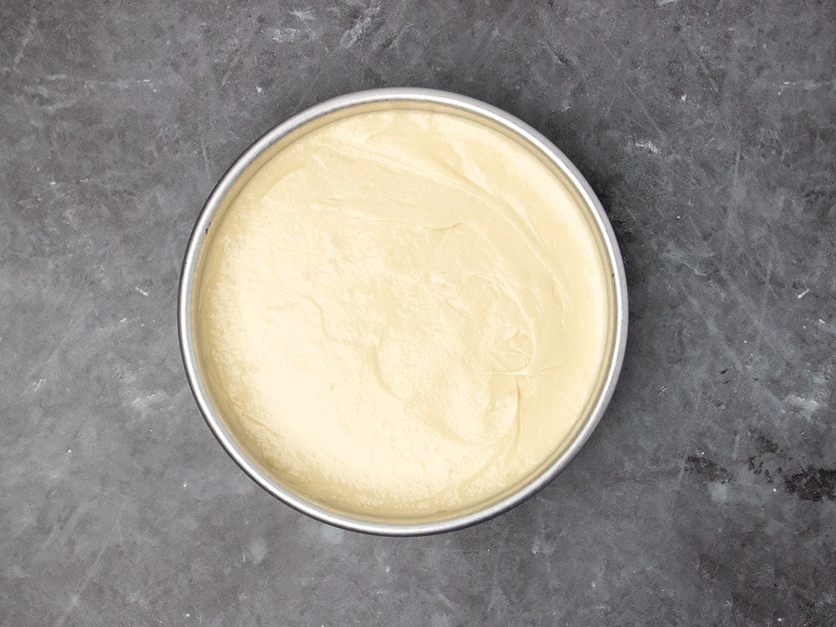 round metal cake pan with light yellow batter in an even layer