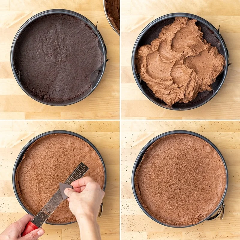 Round metal springform pan with brown cookie crumb layer, topped with soft light brown filling, chocolate being shaved on top and the whole cake