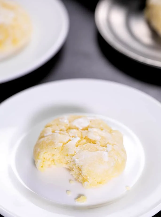 Round yellow cookie with a bite taken on small white plate