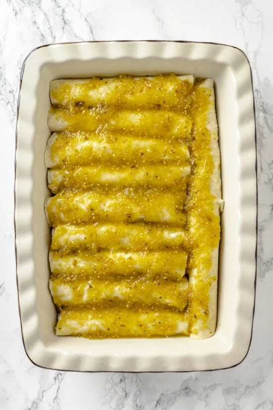 Salsa verde poured over enchiladas