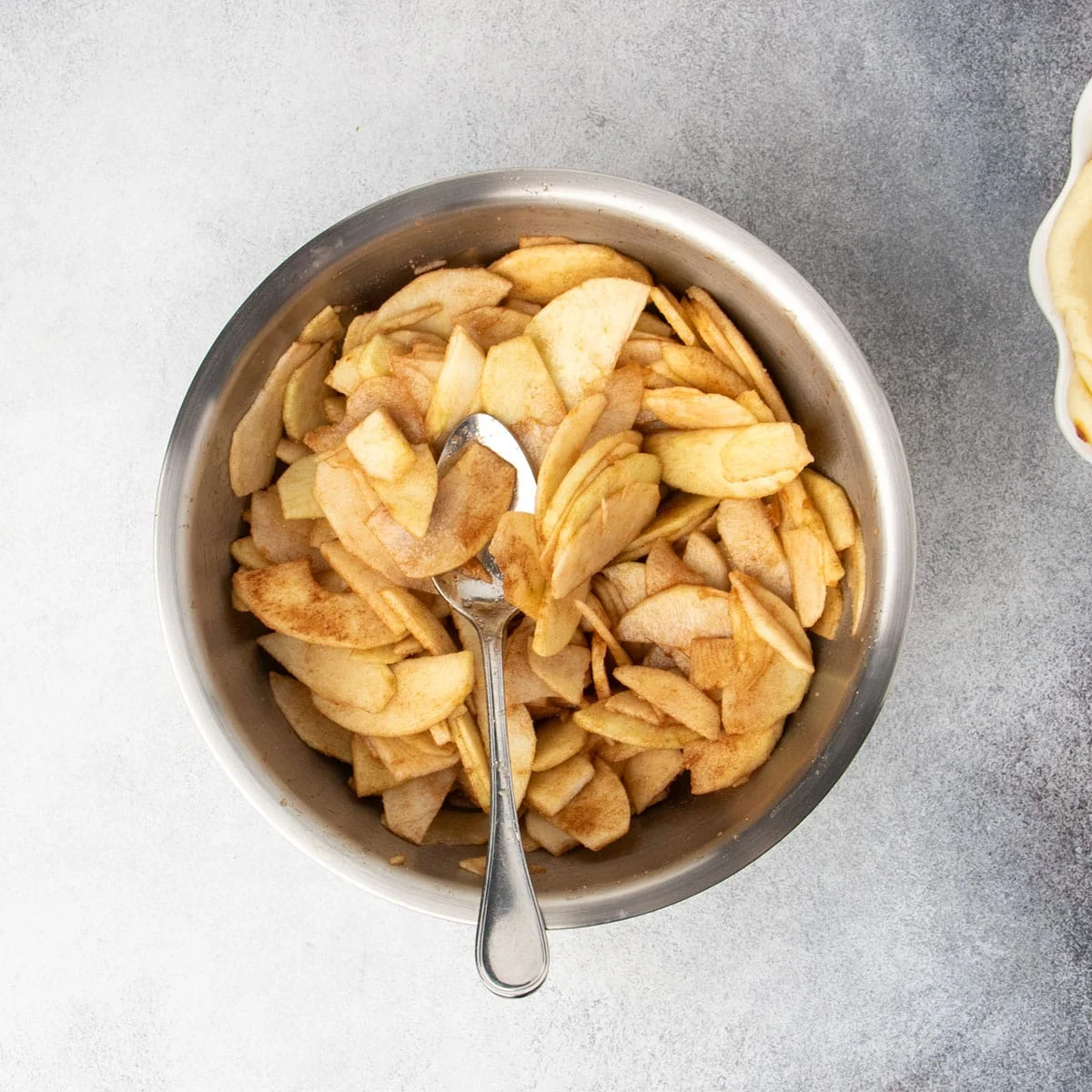 Same apple slices tossed with sugar and cinnamon, ready to be added to the pie crust.