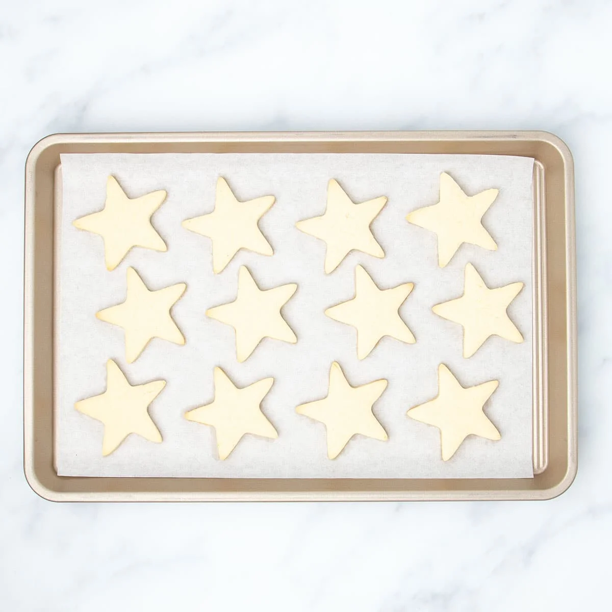 Same baking sheet with 12 baked cookie stars.