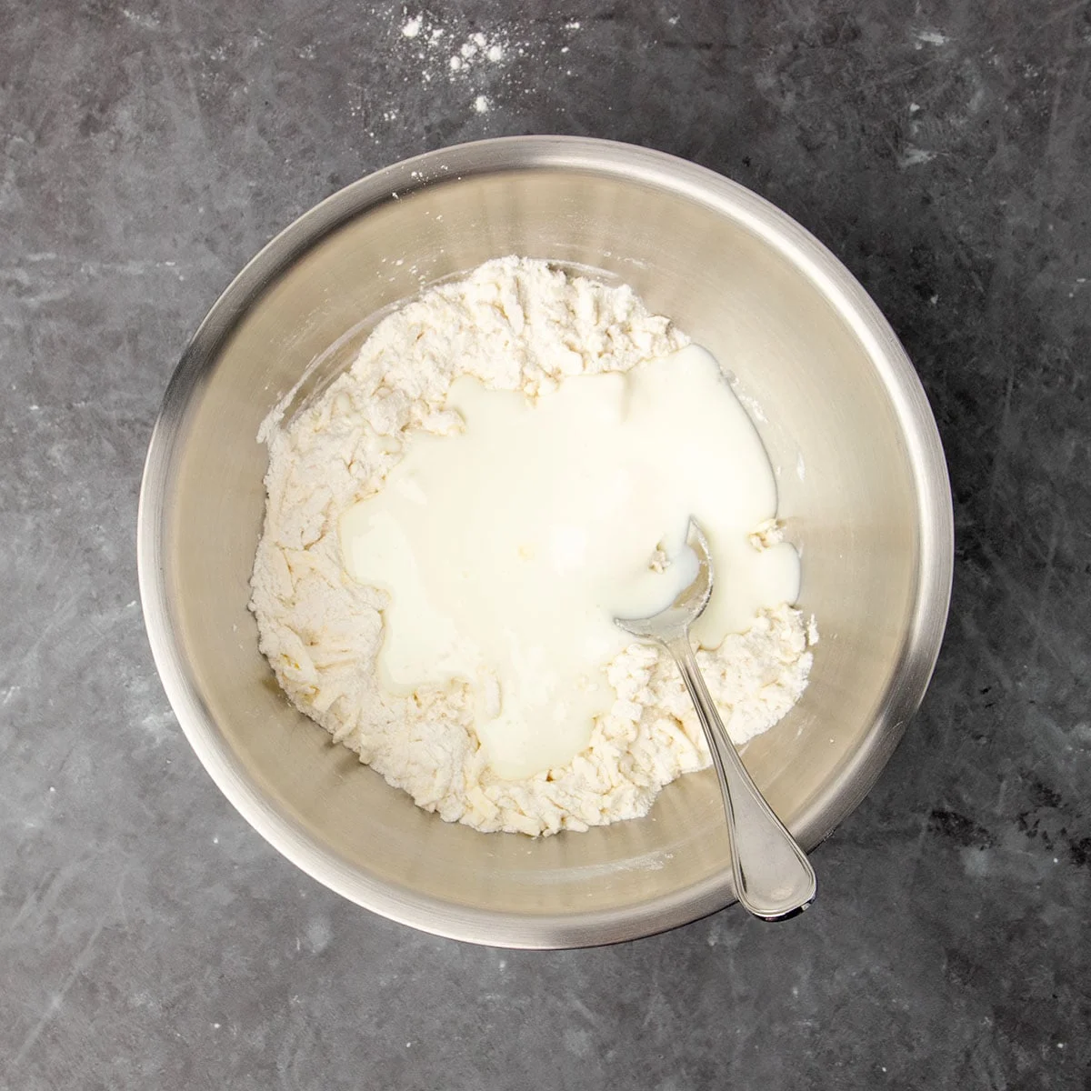 same bowl with flour and butter with white buttermilk on top