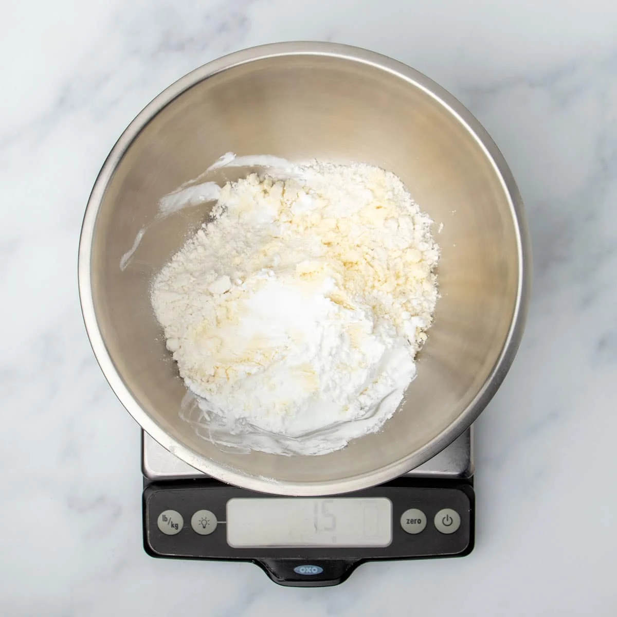 same bowl with more starch white powder on top on the same scale reading 15 grams