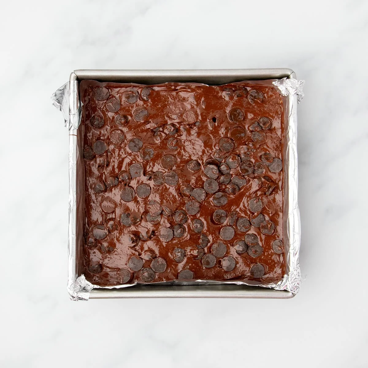 Same raw, shiny brown batter with chocolate chips pressed into the top