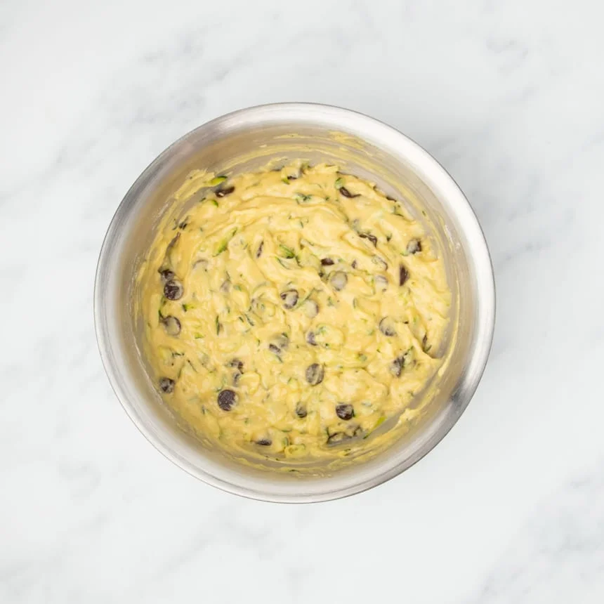 Same raw yellow batter with green flecks with dark brown chocolate chips mixed in.