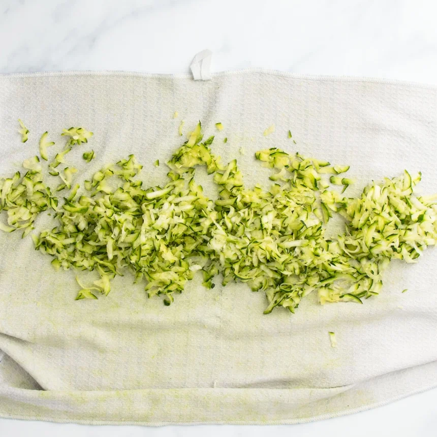 same zucchini shreds on towel that is now open and is tinged green