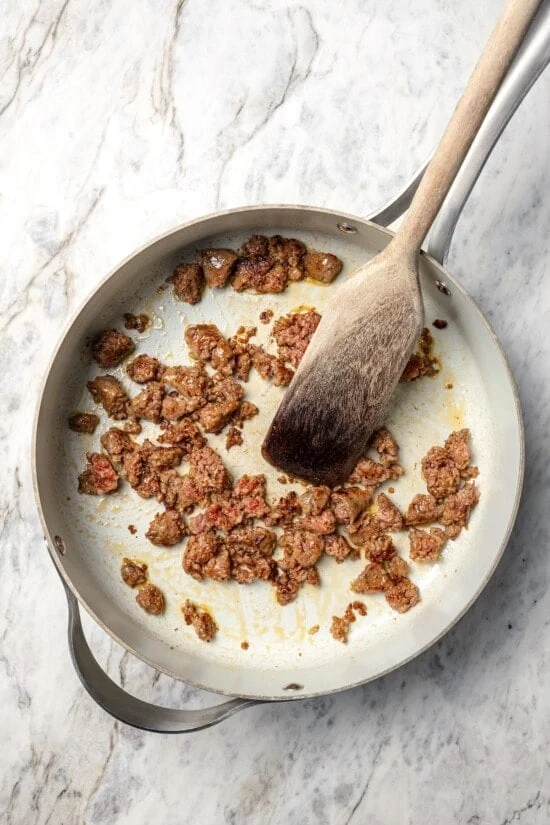Sausage browning in skillet.
