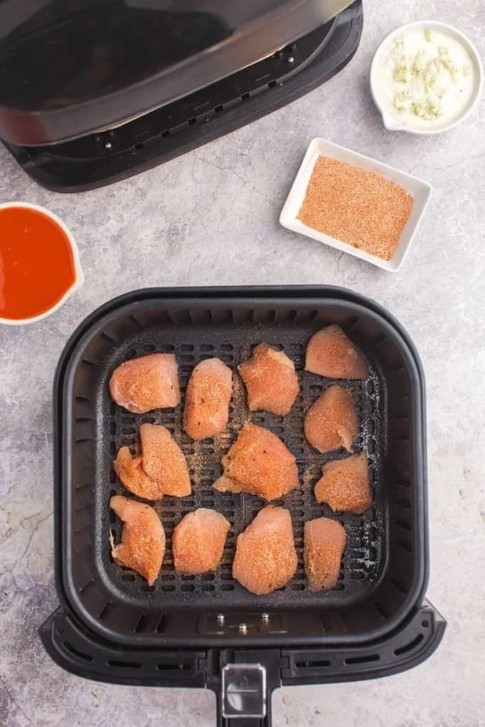 Seasoned boneless wings in air fryer basket