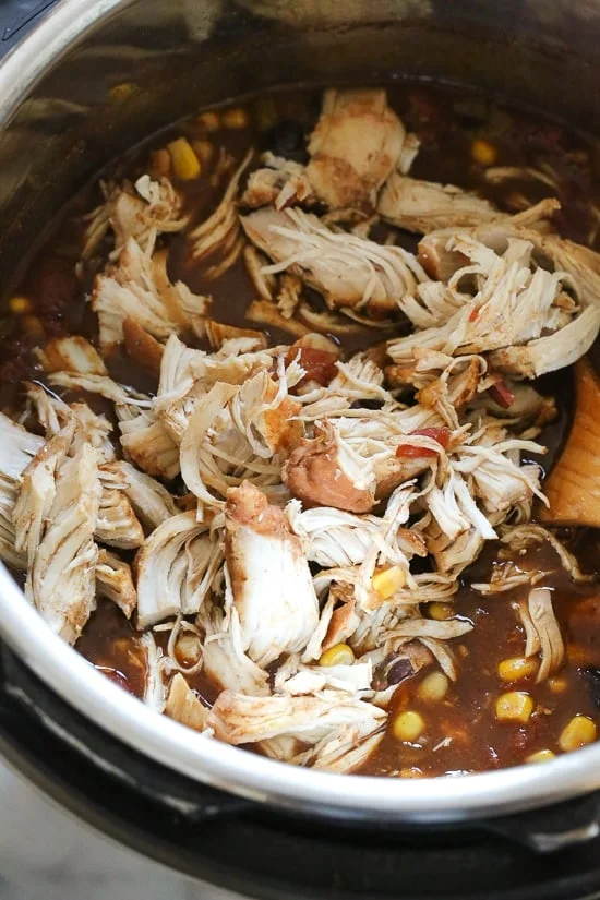 Shredded chicken being stirred into easy taco chili 
