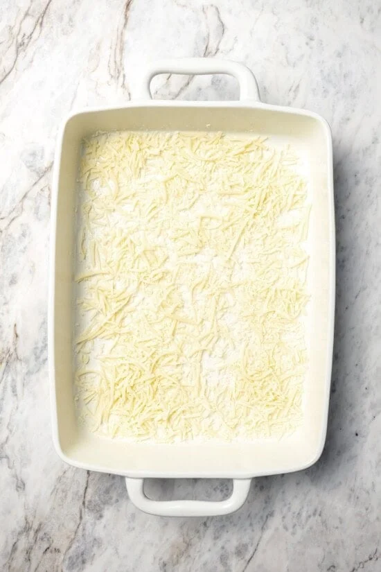 Shredded mozzarella in bottom of baking dish.