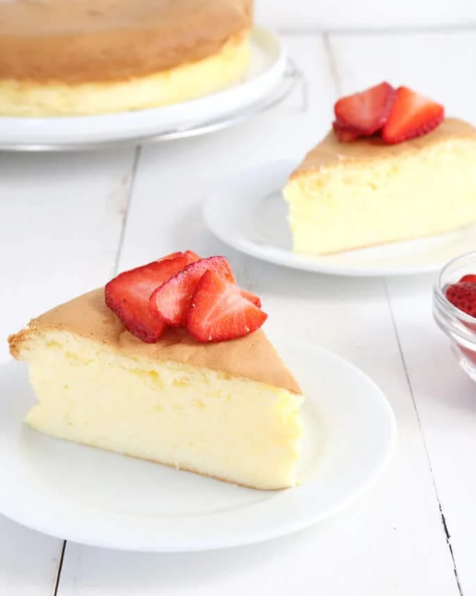 Side view of a slice of Japanese cheesecake on a white plate 
