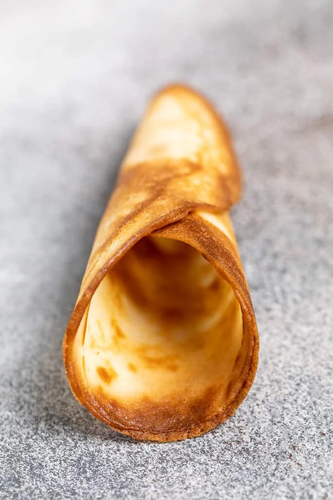 Single sugar cone on its side on speckled gray surface