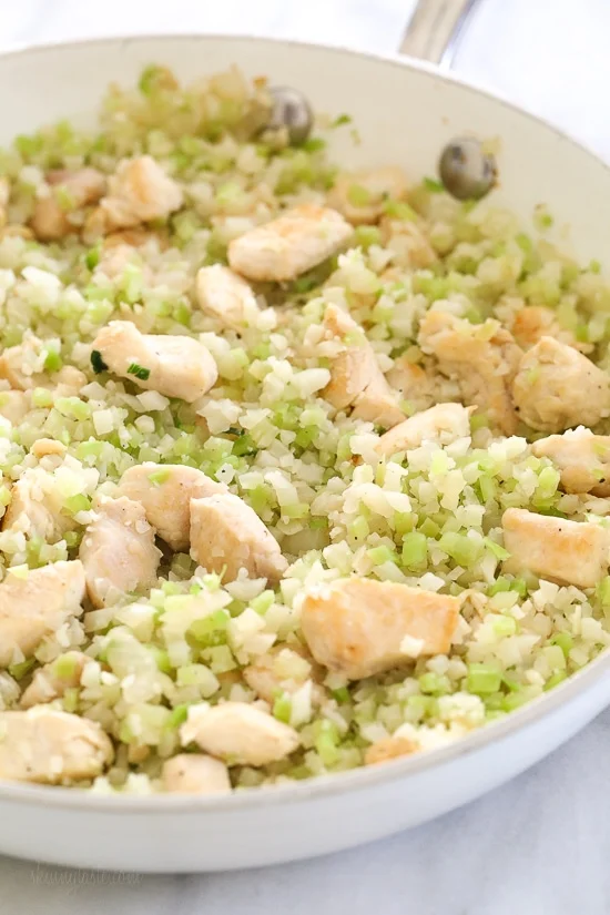 Skillet Cheesy Chicken and Veggie "Rice" made with riced broccoli and cauliflower, sauteed chicken and cheddar cheese. It's so fast and easy to make!