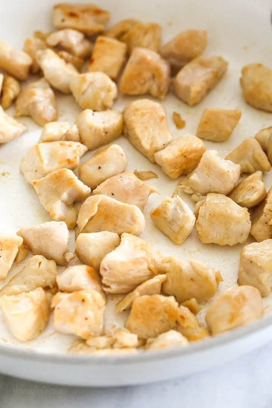 Skillet Cheesy Chicken and Veggie "Rice" made with riced broccoli and cauliflower, sauteed chicken and cheddar cheese. It's so fast and easy to make!