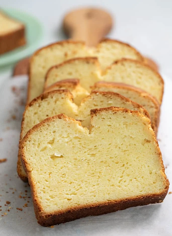 Sliced brioche bread on white paper on a bread board