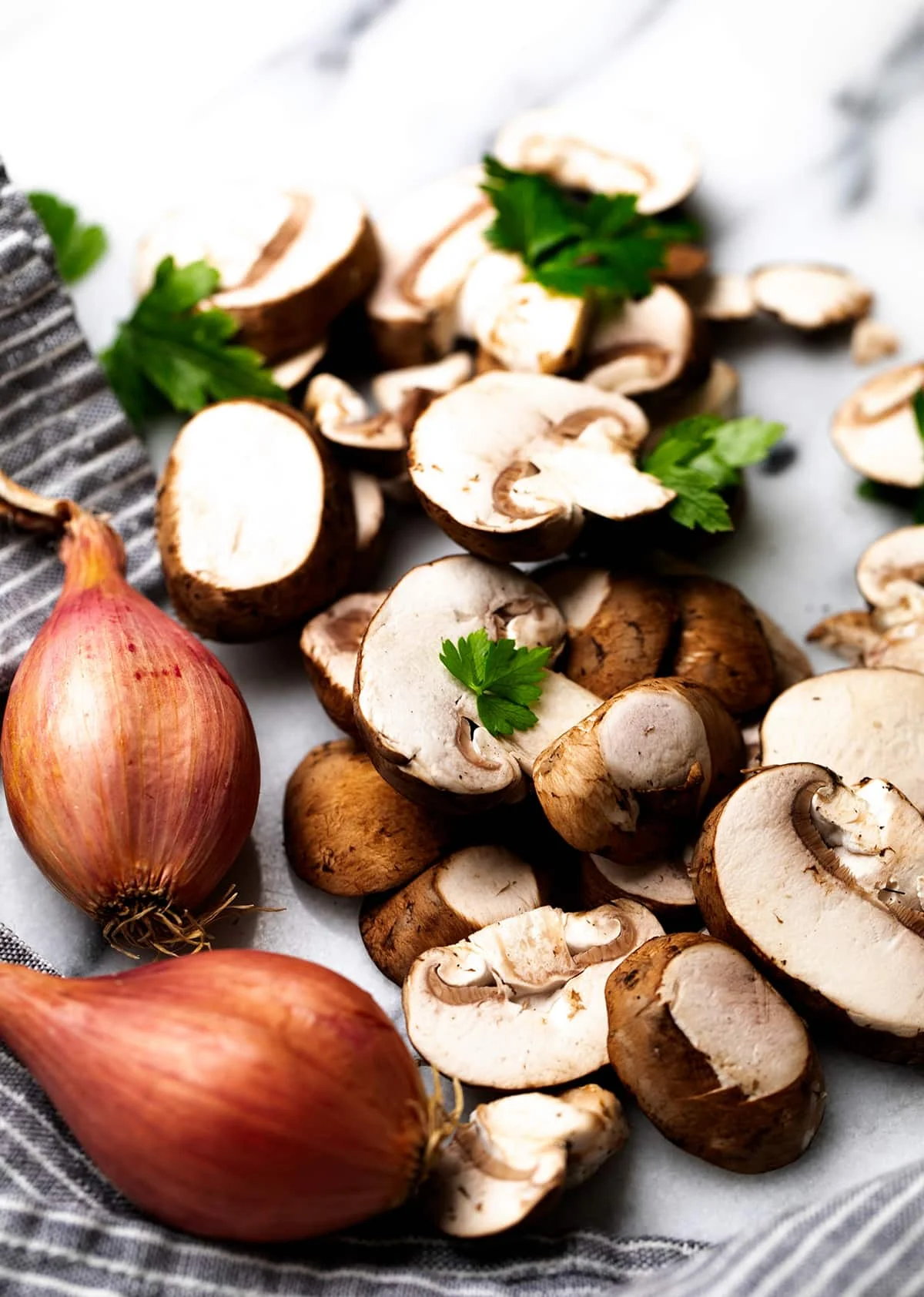 sliced brown mushrooms, whole shallots with brown outer paper, green parsley leaves