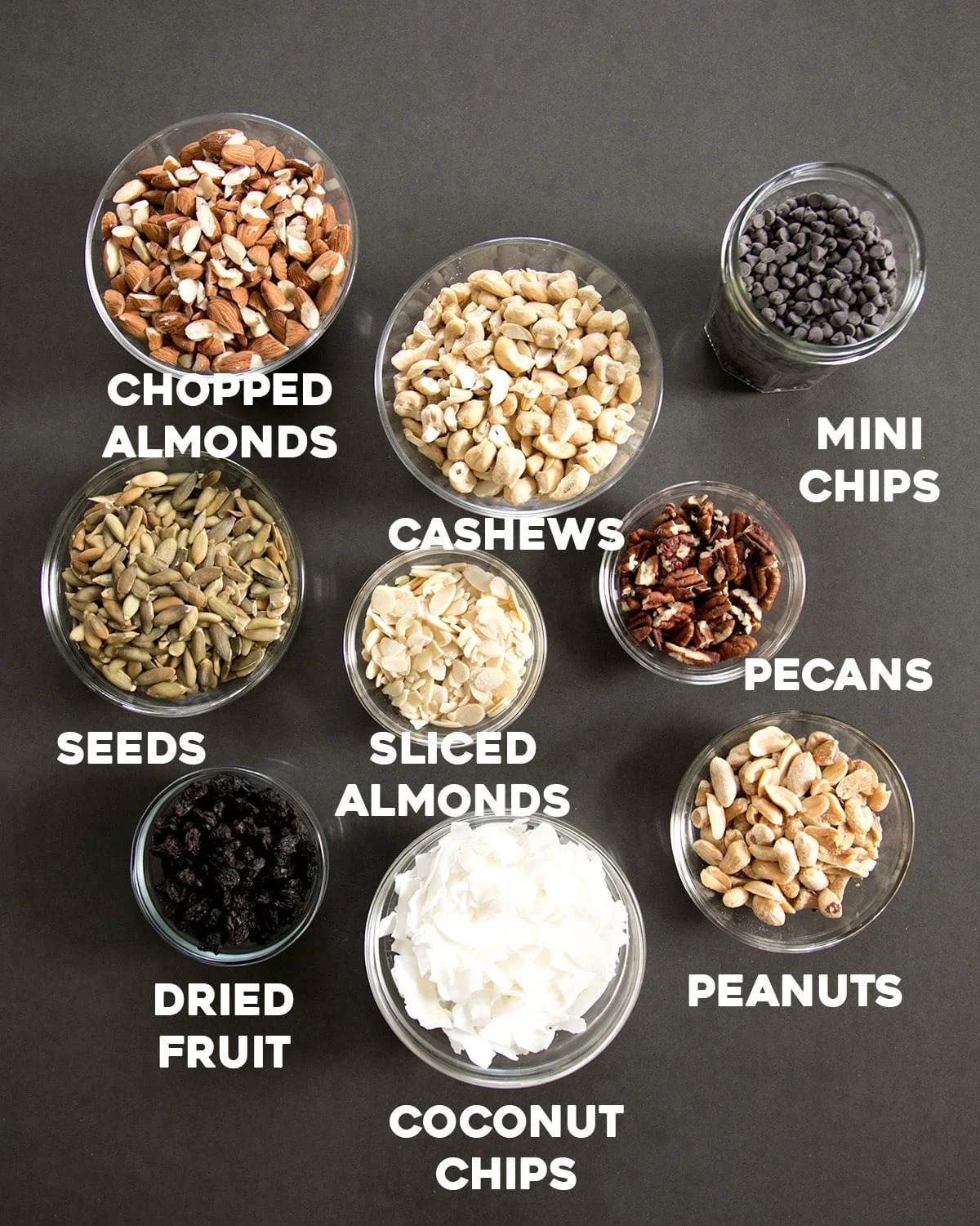 small bowls with mix-in pieces like mini chocolate chips, nuts, seeds, and raisins for homemade granola bars