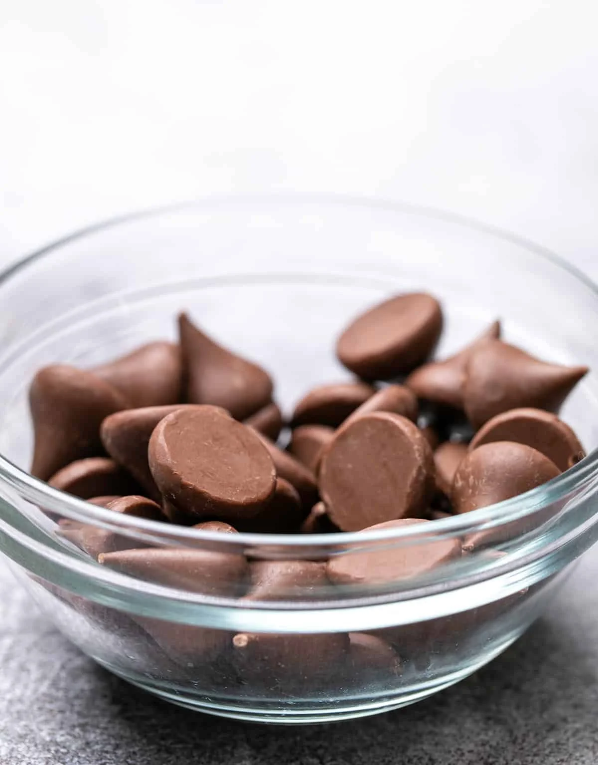 Small glass bowl with unwrapped Hershey's chocolate kisses