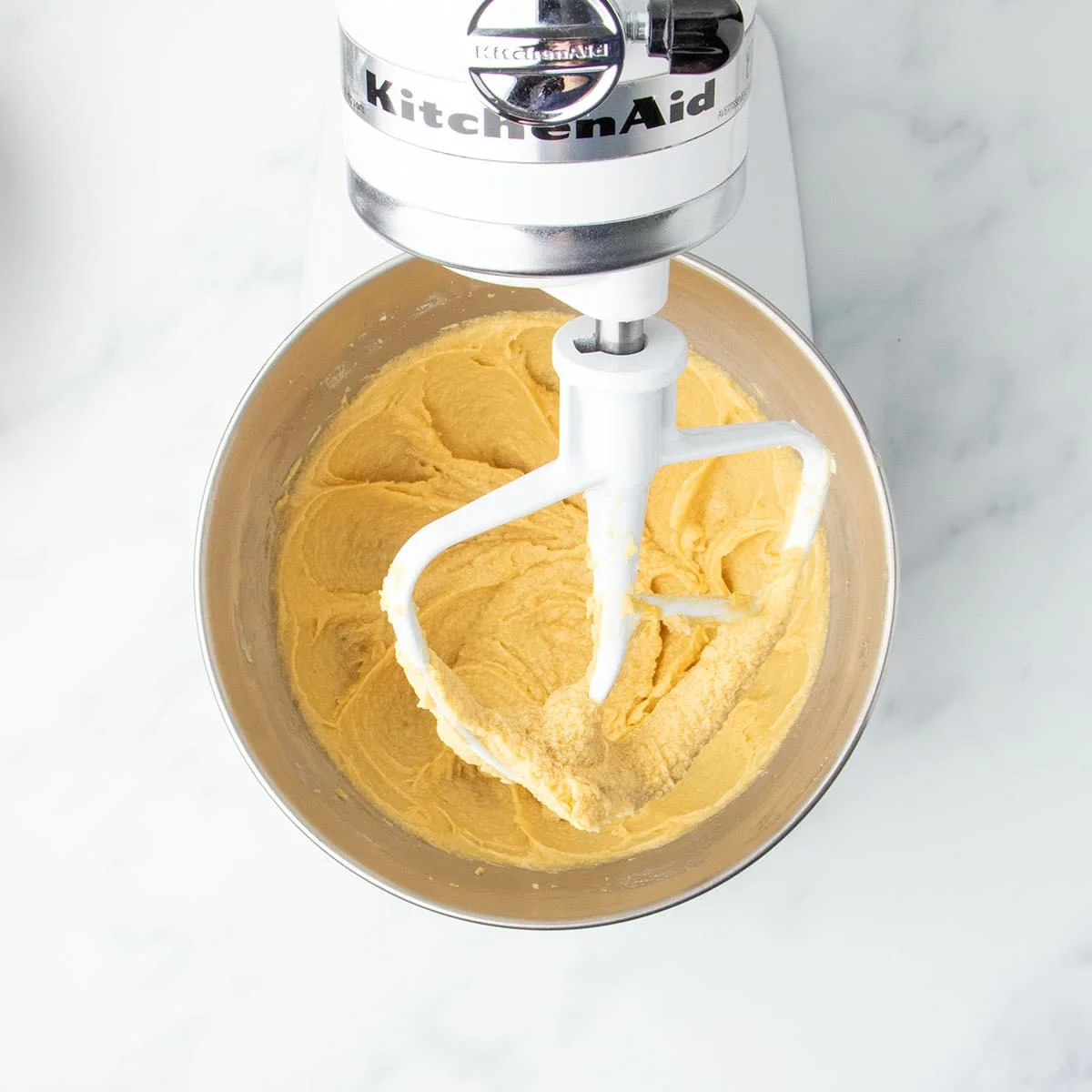 Smooth butter, sugars and egg mixture in stand mixer bowl with white paddle attachment, without chips or gluten free flour.