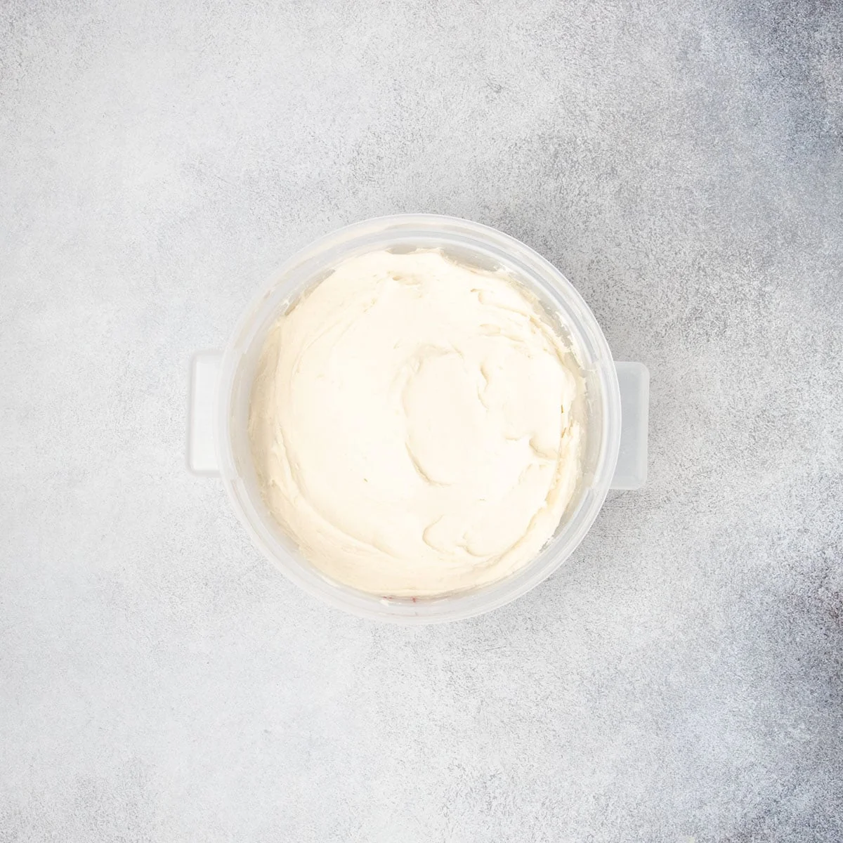 Smooth raw gluten free dough placed in a container, ready to proof.