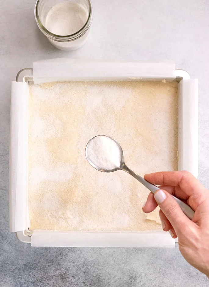 Sour cream sugar cookie bars overhead being sprinkled with sugar