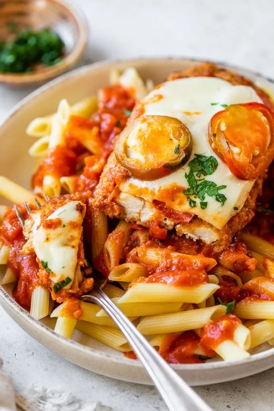 Spicy Vodka Chicken Parmesan on a plate over pasta