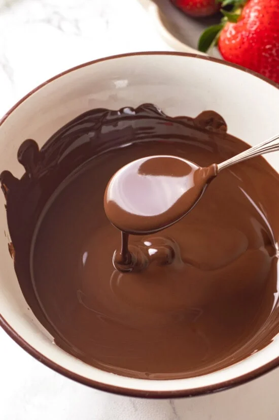 Spoon dripping melted chocolate into bowl